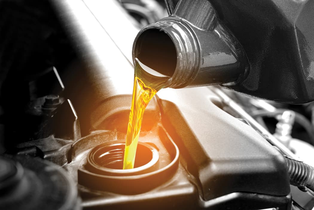 Oil pouring from bottle into engine