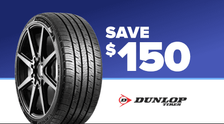 Dunlop tire promotion showing black tire with white text Save $150 on blue background with fireworks pattern