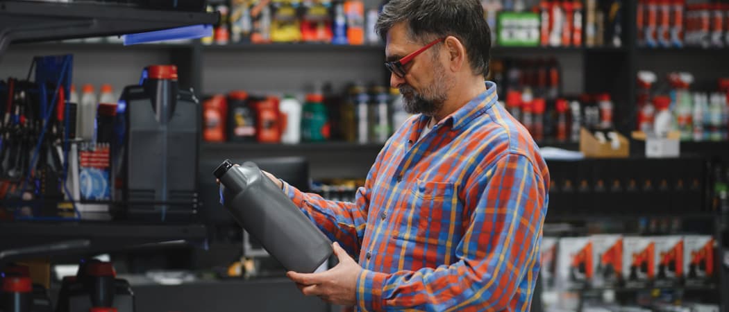 Man looking at bottle of motor oil in auto shop